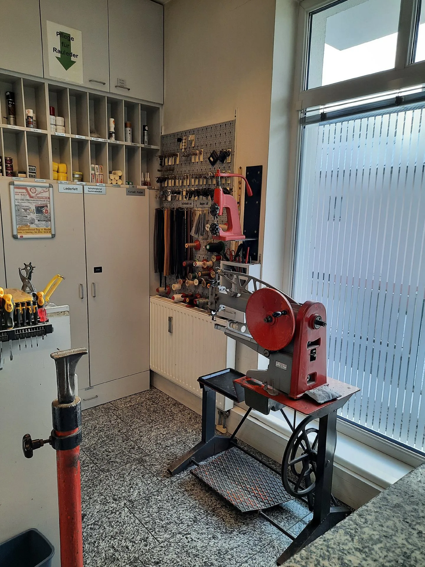 Schuhwerkstatt mit roter Reparaturmaschine